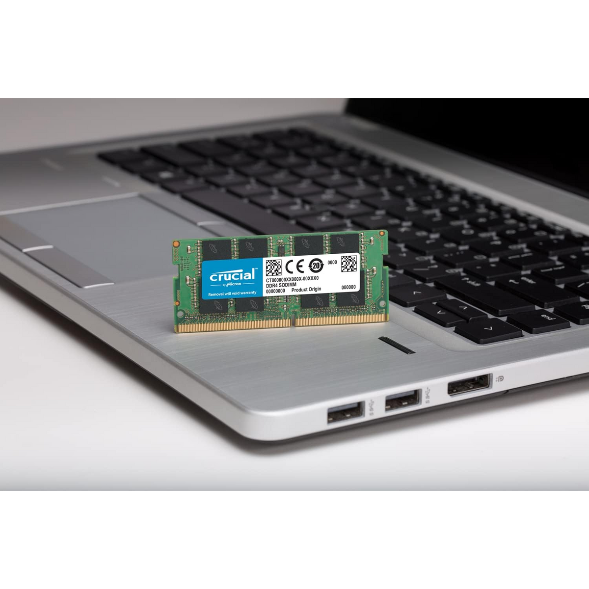 Crucial 16GB DDR4 3200MHz SO-DIMM — module resting on a laptop