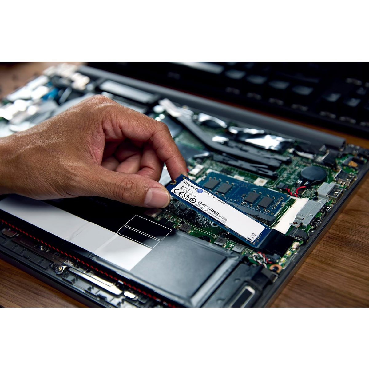 Kingston NV3 1TB PCIe 4.0 NVMe M.2 Internal SSD — being fitted to a laptop M.2 slot
